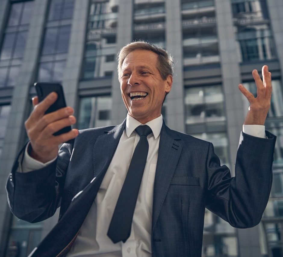 happy-businessman-using-smartphone-on-the-street
